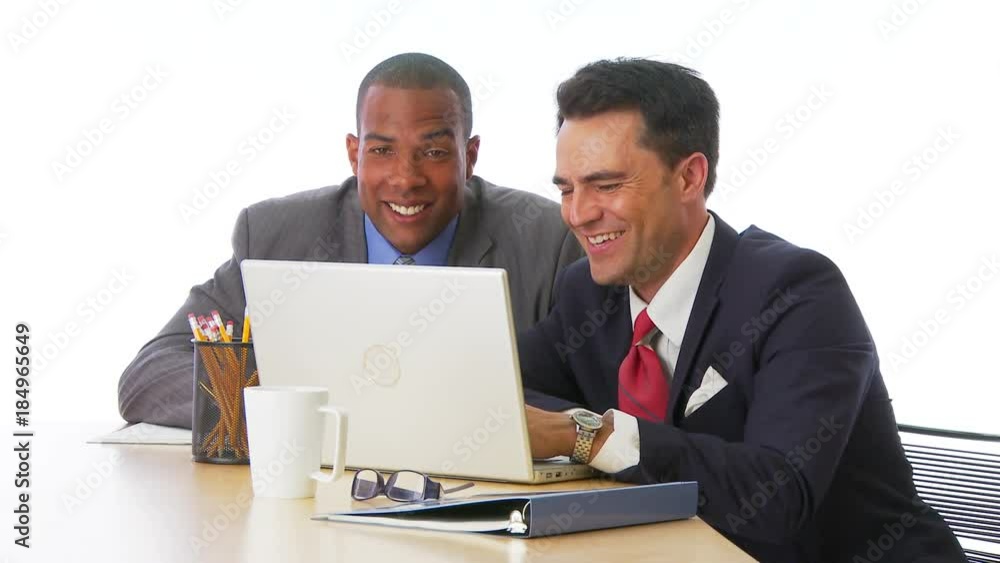 Two businessmen working on computer together Two businessmen working on computer together