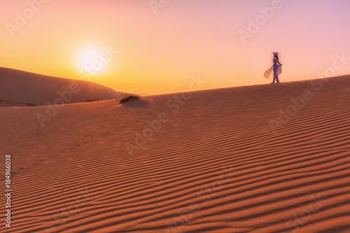 Woman walk alone on The red sand dunes in MUI NE  Vietnam is popular travel destination with long coastline  silver sand and huge sea waves.