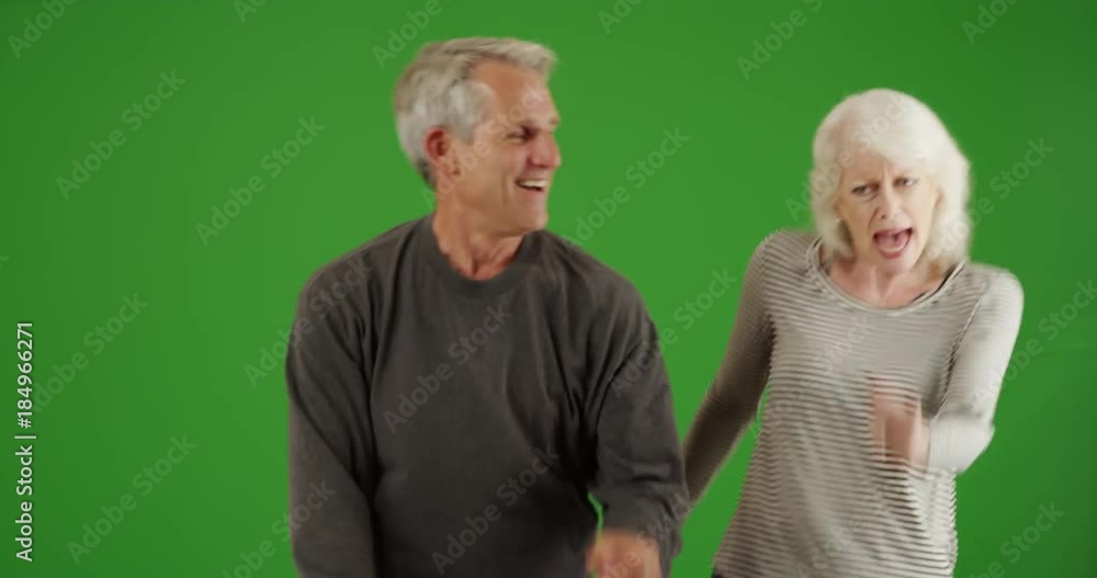 Active senior couple dancing together in the living room on green screen. On green screen to be keyed or composited. Active senior couple dancing together in the living room on green screen. On green screen to be keyed or composited.