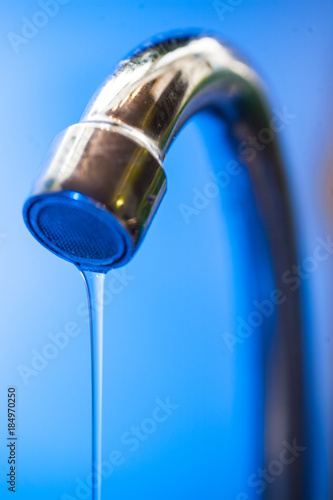 Tap with dripping waterdrop. Water leaking, saving.