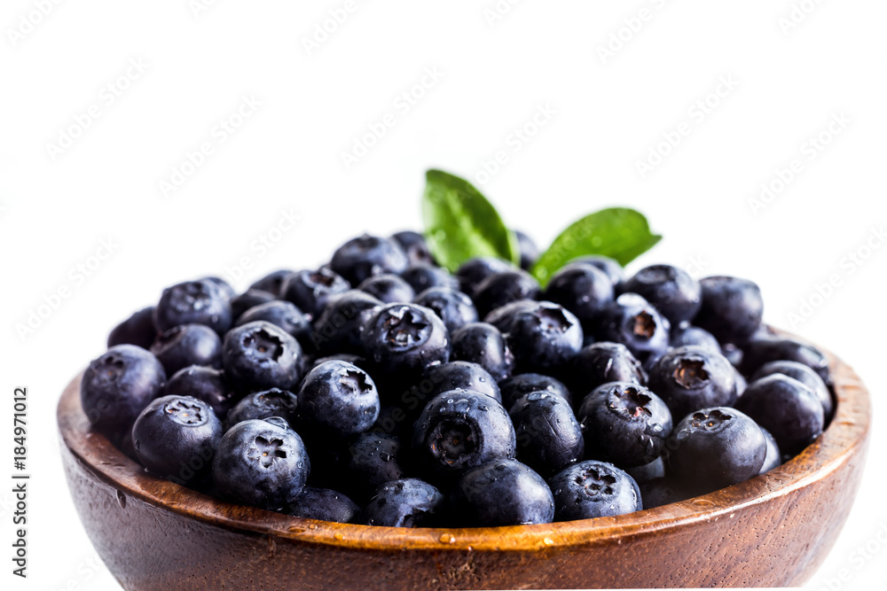 Juicy and fresh blueberries with green leaves on white bowl. Healthy eating Juicy and fresh blueberries with green leaves on white bowl. Healthy eating