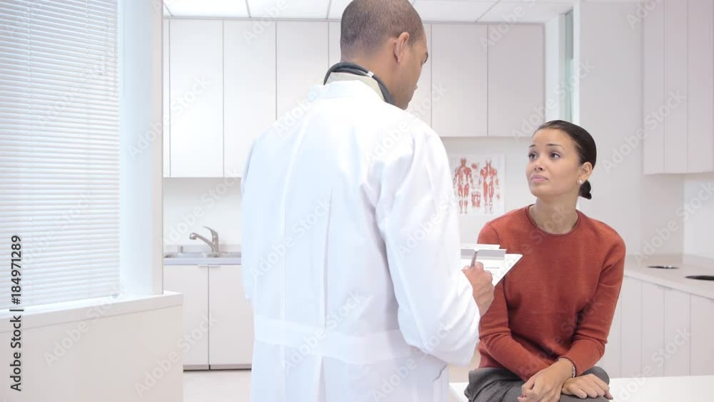 Doctor consulting patient in exam room Doctor consulting patient in exam room