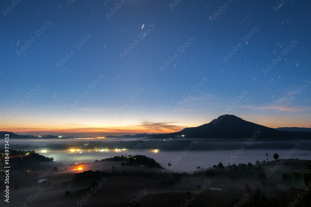 Landscape night sky with star tail and fog in morning sunriseat Khao Takhian Ngo View Point at Khao-kho Phetchabun,Thailand
