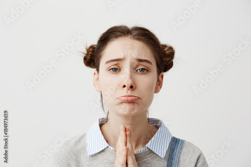 Photography Portrait of girl 20s with upset look begging for mercy being disappointed with praying gestures