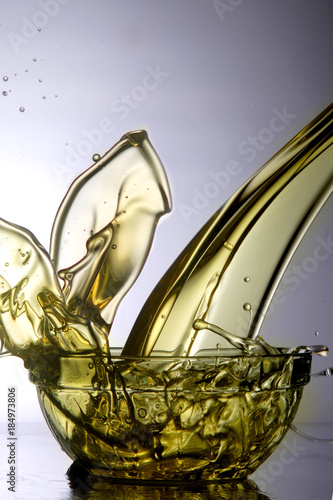 Liquid cooking oil splashes when poured into a glass bowl