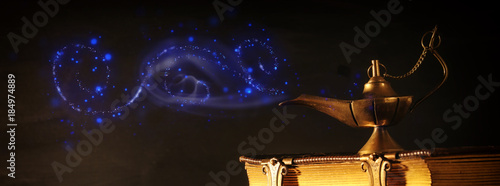 Image of magical aladdin lamp and old books. Lamp of wishes.