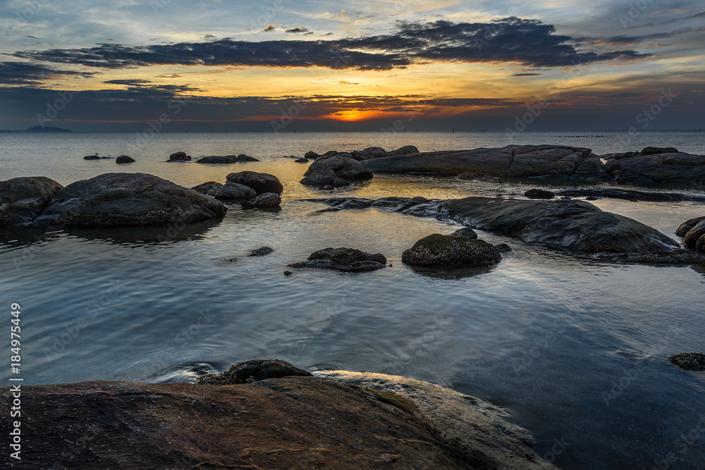 Rocks in the sea with sunset sky.