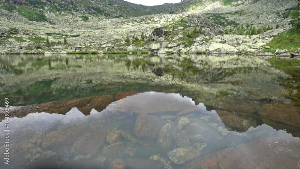 Rocky peaks are reflected in a mountain lake. Western Siberia, Ergaki range. Rocky peaks are reflected in a mountain lake. Western Siberia, Ergaki range.