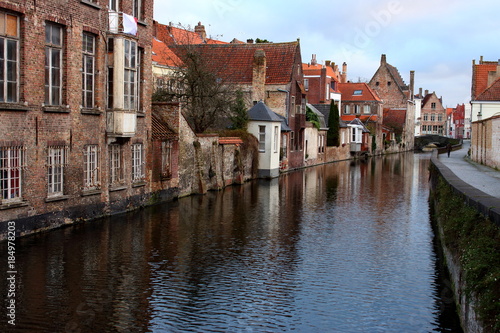 Old town Brugge (Bruges), Belgium. Medieval buildings exterior with tiled roofs and reflection in river. Brick ancient houses and walls. Medieval architecture in Europe while travel. Winter Brugge.