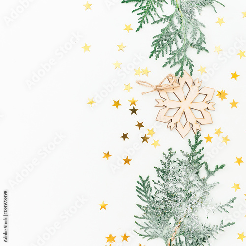 New Year composition made of fir branches  decoration with golden confetti on white background. Flat lay  top view