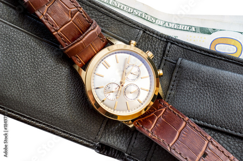 Wrist watch on wallet with money. Close up. Isolated on white.