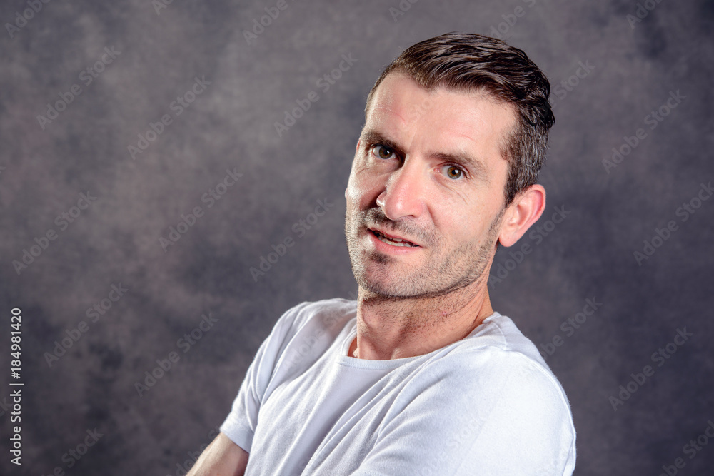 friendly man with crossed arms in front of gray background friendly man with crossed arms in front of gray background