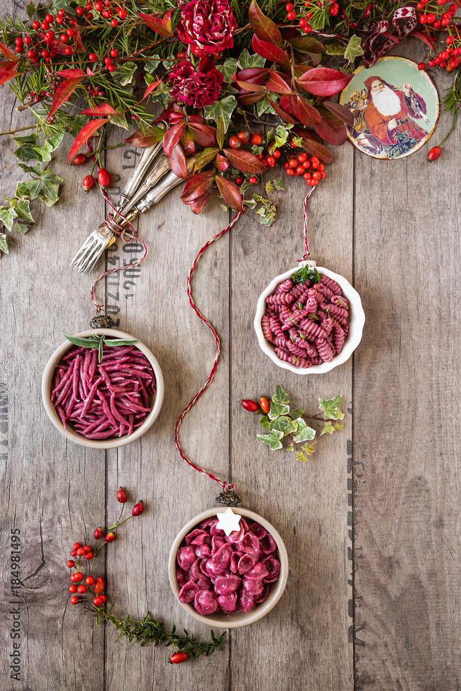 natale italiano: pasta in piccole ciotole come palline di natale e composizione con fiori e foglie natale italiano: pasta in piccole ciotole come palline di natale e composizione con fiori e foglie