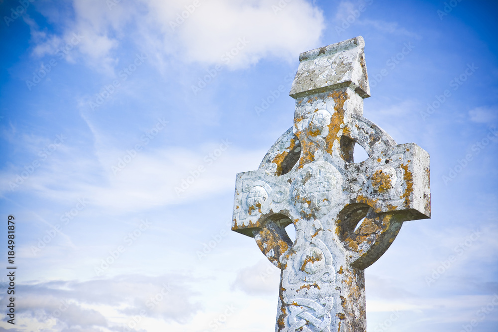 Celtic carved stone cross against a sky background - image with copy space