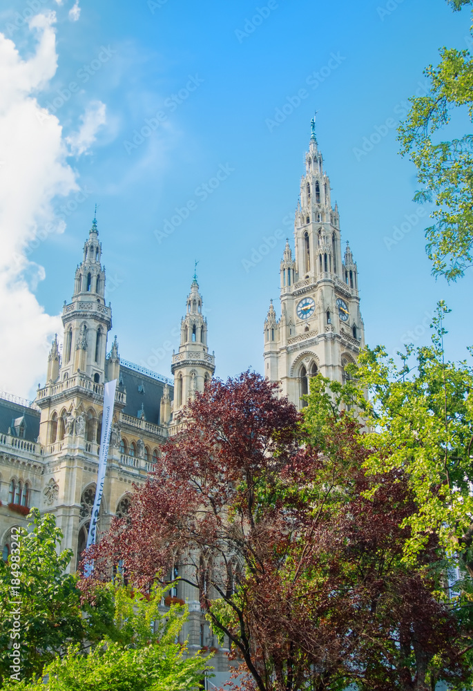 VIENNA, AUSTRIA - JULY 29, 2016: City hall (Rathaus) ant high trees in the park on sunny summer day at Vienna, Austria.
