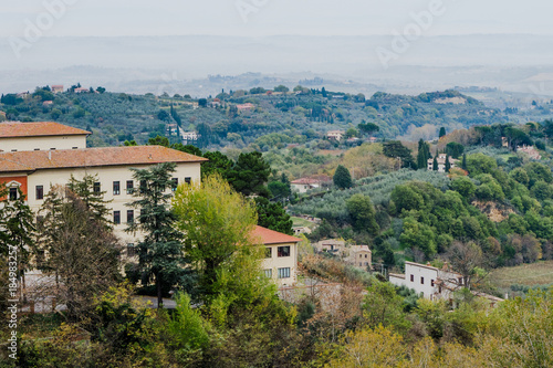 Tuscan landscape with trees  houses and green hills in Tuscany  Italy