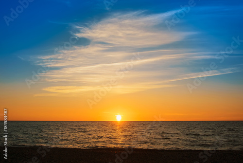 A beautiful bright colorful seascape with setting sun, colorful evening twilight landscape, abstract background of holiday relaxing vacation by the sea.