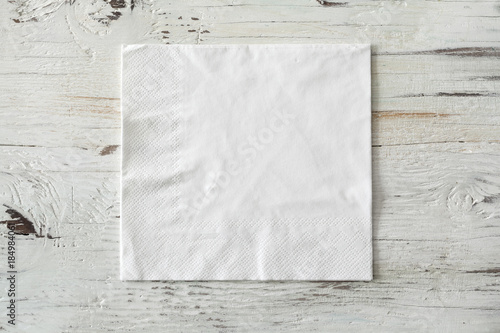 White paper napkin on wooden background photo