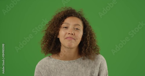Happy laughing mixed-race millennial woman talking over video chat conference call on green screen. On green screen to be keyed or composited. 