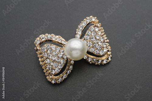 gold brooch bow with pearls and gems isolated on black