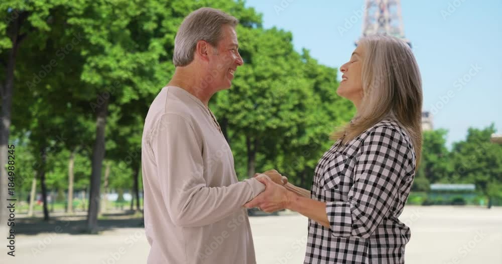 Old white man and woman express love to each other near Eiffel Tower Old white man and woman express love to each other near Eiffel Tower