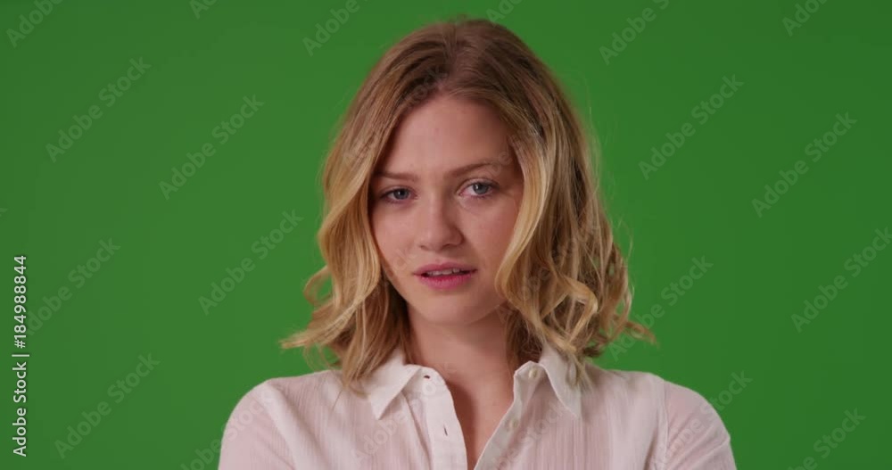 Close up of attractive Caucasian female dressed in white button down looking confidently at camera on green screen. On green to be keyed or composited. Close up of attractive Caucasian female dressed in white button down looking confidently at camera on green screen. On green to be keyed or composited.