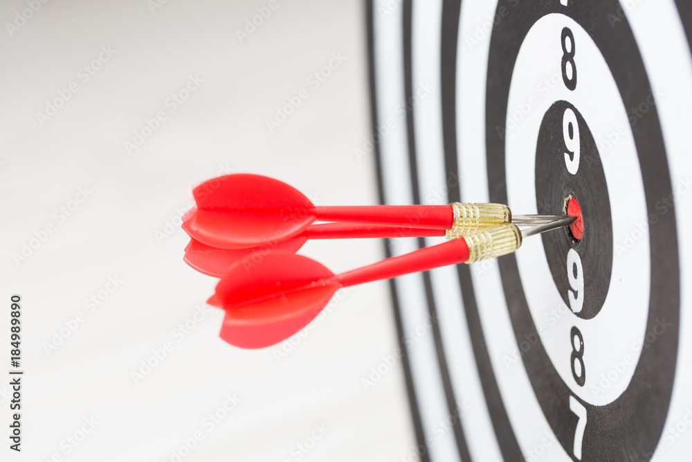 Target dart arrow hitting in the center of dartboard Target dart arrow hitting in the center of dartboard