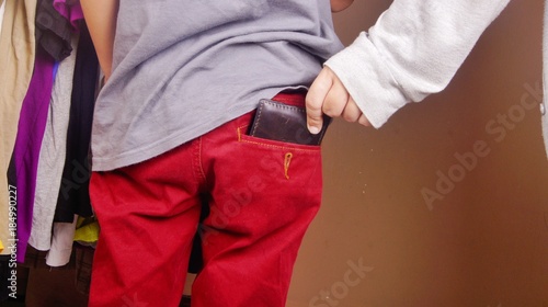 Thief pulling out wallet from victim pocket