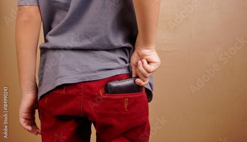 Hand pulling out from or putting in wallet in back pocket