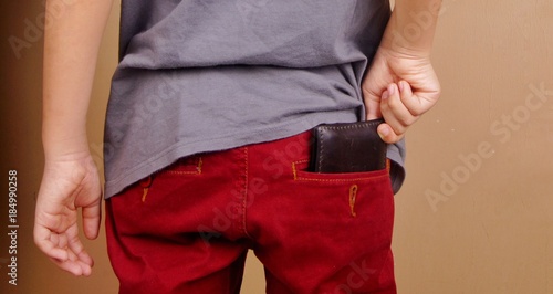 Hand pulling out from or putting in wallet in back pocket
