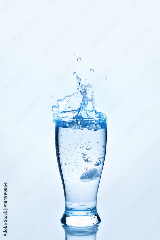The ice cubes lapping in water glass. Water splashes, Background with copy space. The ice cubes lapping in water glass. Water splashes, Background with copy space.