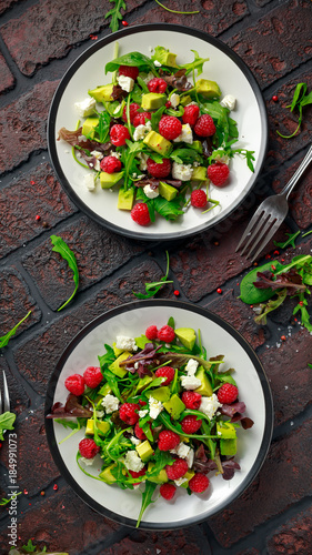 Fresh Tasty Raspberry salad with avocado, green vegetables, nuts, feta cheese, olive oil and herbs. healthy food.