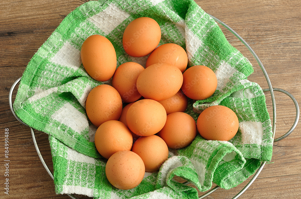 Eggs in a green cloth inside a wire basket Eggs in a green cloth inside a wire basket