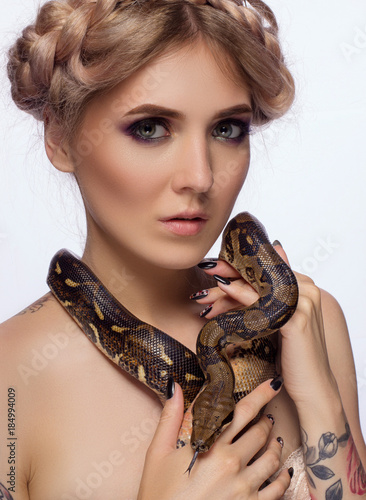 Pretty tattooed girl with python isolated shot