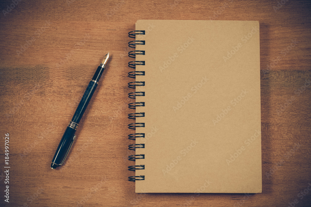 Book note and fountain pen on wood table. Book note and fountain pen on wood table.