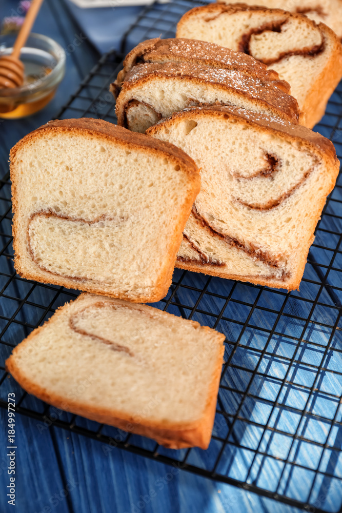 Naklejka premium Baking rack with delicious cinnamon roll cake on table