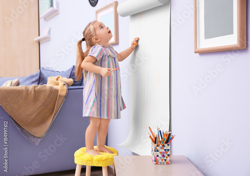 Little cute girl drawing on...