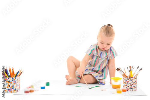 Little girl painting agains...