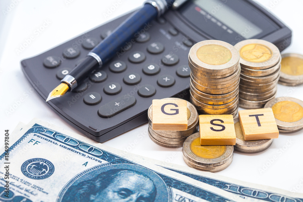 Fototapeta premium Goods and Services Tax word on stack coins isolate .