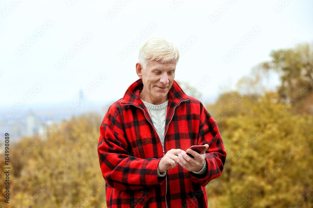 Handsome mature man using phone outdoors Handsome mature man using phone outdoors