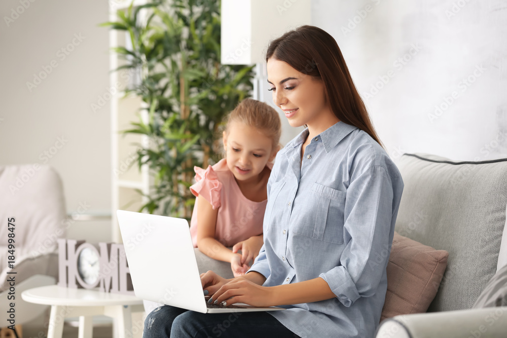 Busy young woman with daughter in home office Busy young woman with daughter in home office