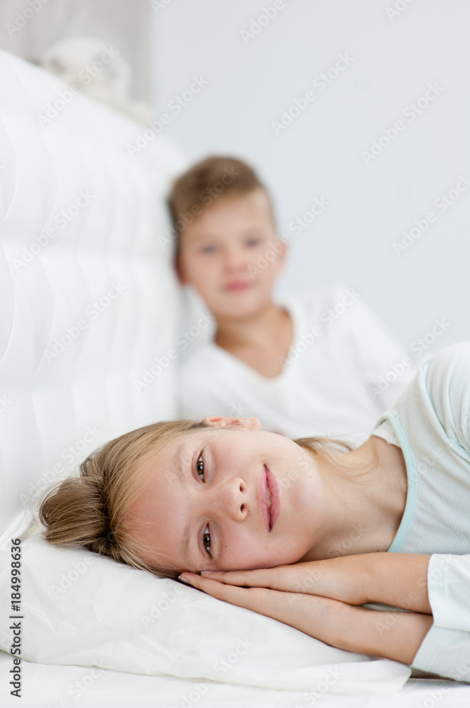 Happy brother and sister lying on bed Happy brother and sister lying on bed