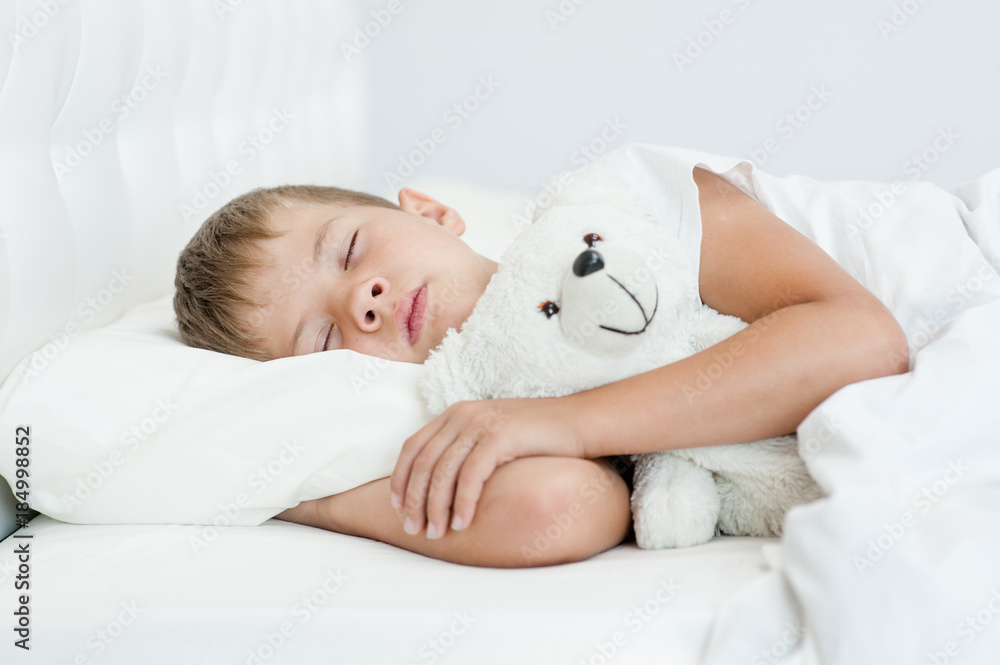Little boy sleeping on the bed with toy bear Little boy sleeping on the bed with toy bear