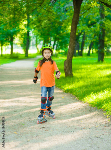 Girl learn to roller skate in summer park