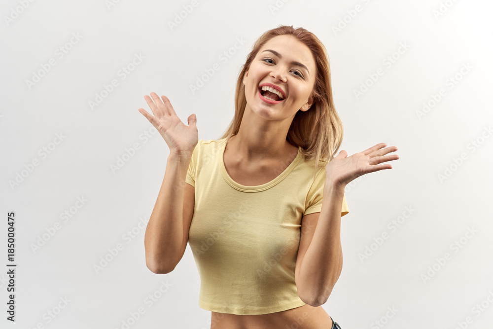 isolated high contrast Studio portrait of happy joyful young woman girl in yellow shirt with rapturous emotions and a distribution hand in hand and cheering. isolated high contrast Studio portrait of happy joyful young woman girl in yellow shirt with rapturous emotions and a distribution hand in hand and cheering.