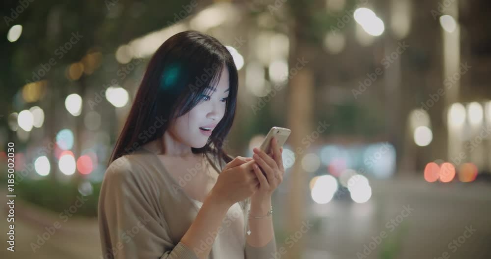 Attractive asian Woman using Mobile Phone During Walk on Streets of Night Town, steadycam shot Attractive asian Woman using Mobile Phone During Walk on Streets of Night Town, steadycam shot