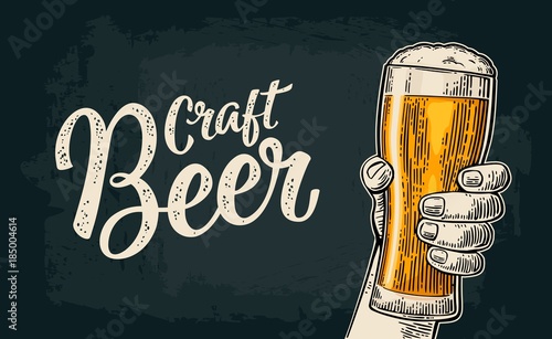 Male hand holding beer glass. Born to drink beer