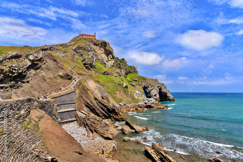 View from the coast on the rock in the ocean with a chapel Doniene Gaztelugatxeko photo