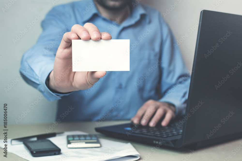 Businessman showing a business card in his business desk. Businessman showing a business card in his business desk.