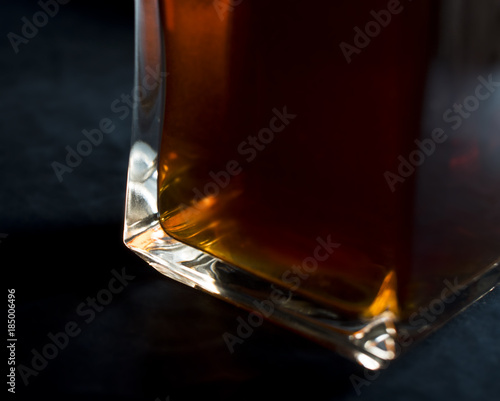 Whiskey/Rom/liquor in a vintage bottle pictured close up with a side light and dark blue velour